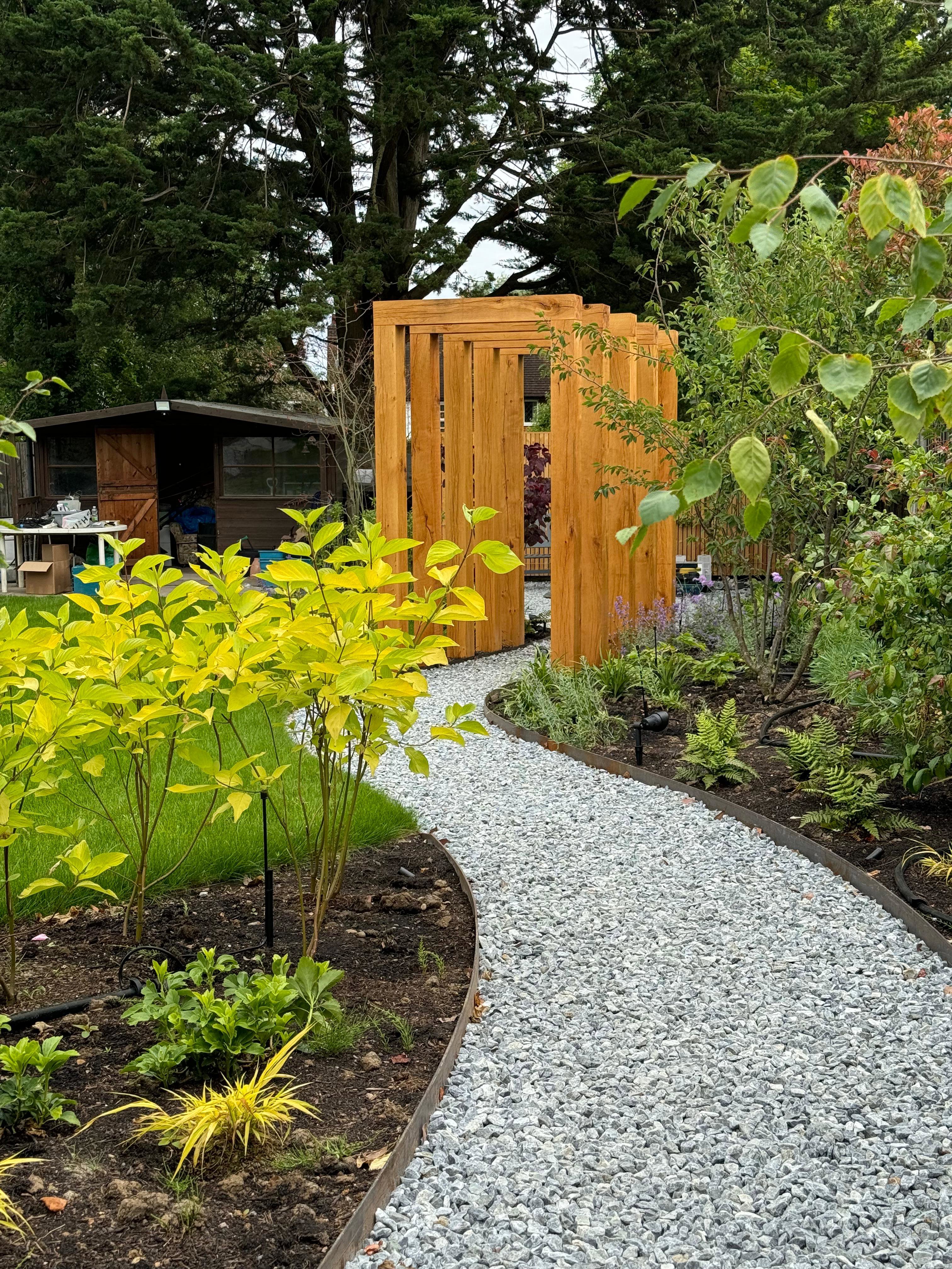 Pathway and flower bed leading up to bespoke wooden arch