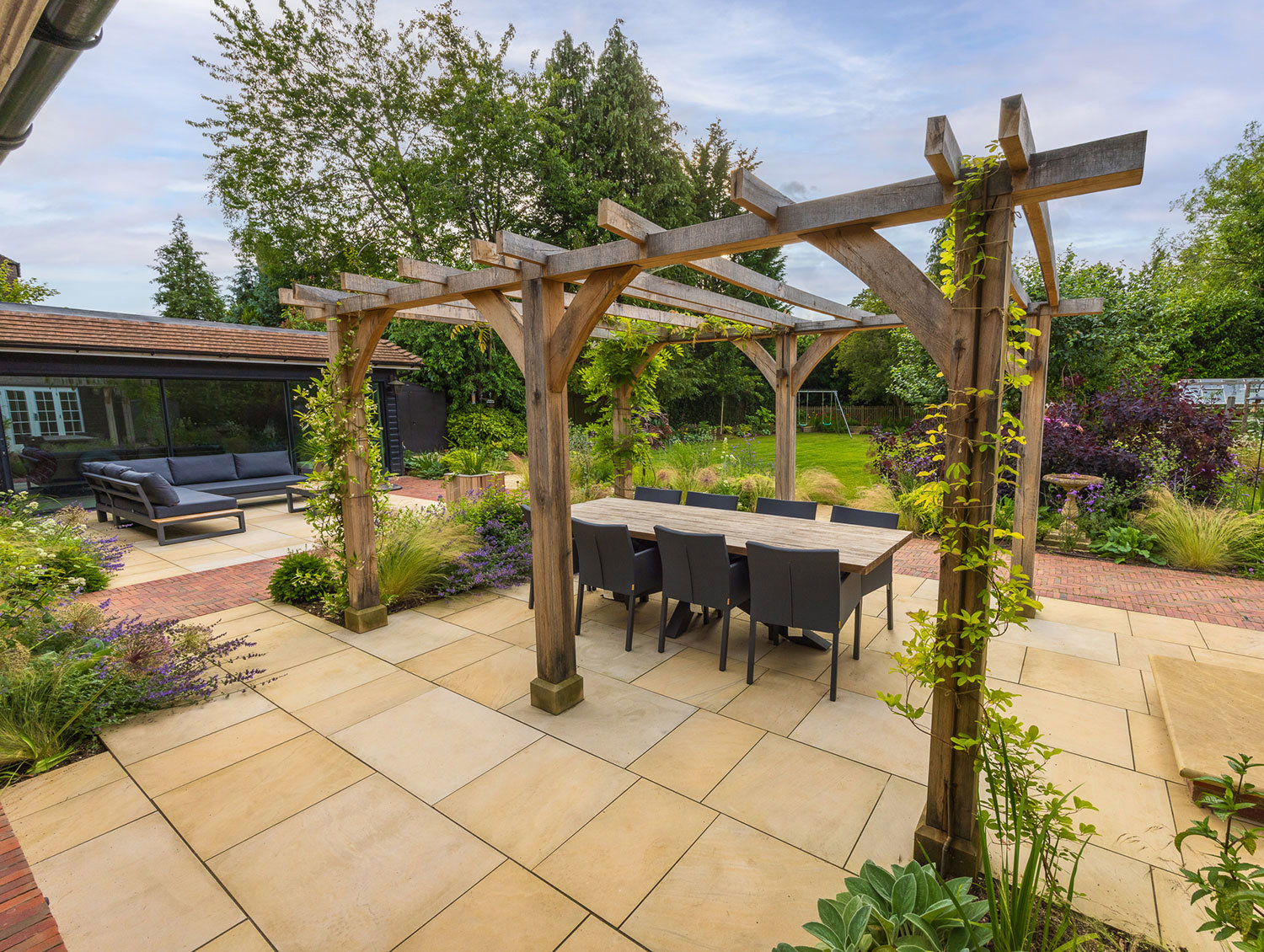 Oak pergola strewn with scented climbers